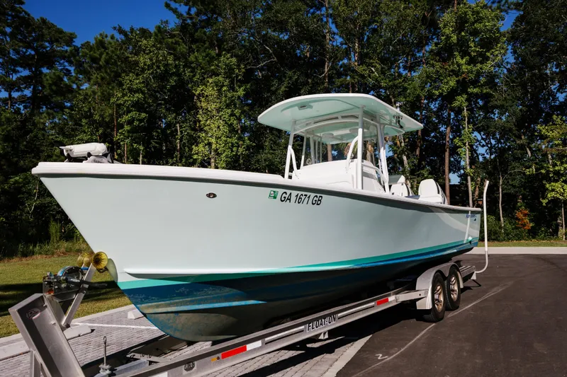  Yacht Photos Pics 2017 Albury Brothers center console boat on trailer, surrounded by trees.