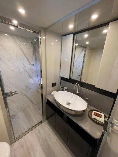  Yacht Photos Pics Luxurious bathroom on 2019 Absolute 62 Fly yacht with modern fixtures and marble accents.