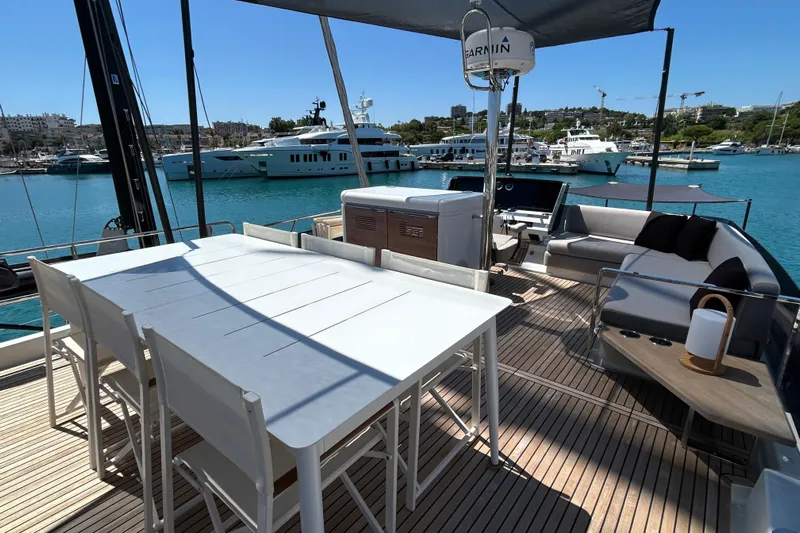  Yacht Photos Pics Luxurious 2022 Prestige X60 yacht deck with dining area and seating, docked in a marina.