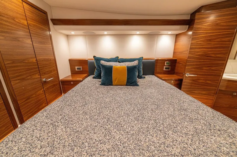 Game On Yacht Photos Pics Luxurious bedroom interior of 2025 Viking 58 Convertible yacht with elegant wood finishes.