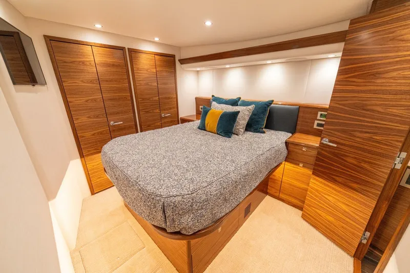 Game On Yacht Photos Pics Luxurious bedroom interior of 2025 Viking 58 Convertible yacht with wood finishes and cozy bedding.