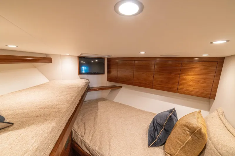Game On Yacht Photos Pics Luxurious cabin interior of 2025 Viking 58 Convertible yacht with cozy bedding and TV.