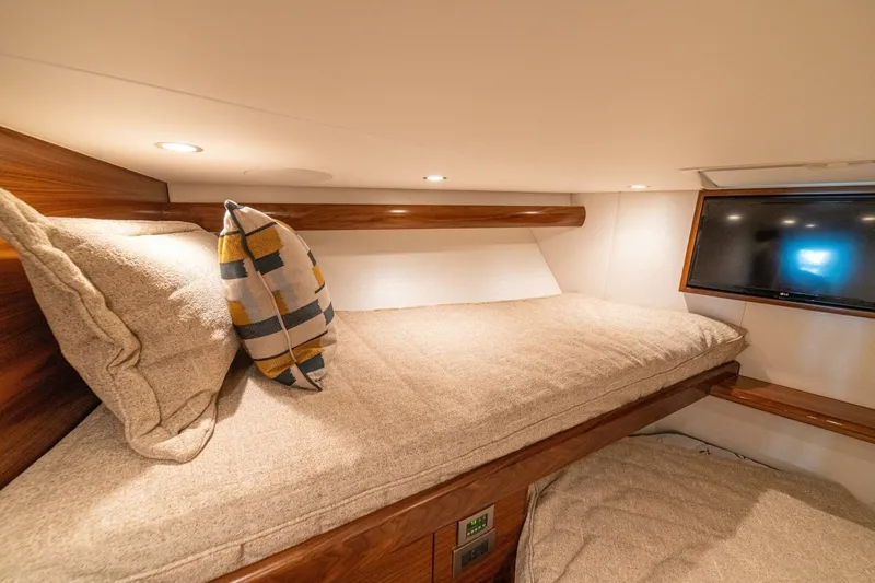 Game On Yacht Photos Pics Cozy cabin interior of 2025 Viking 58 Convertible yacht with TV and plush bedding.