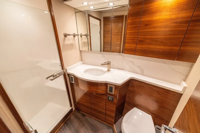 Game On Yacht Photos Pics Luxurious bathroom in 2025 Viking 58 Convertible yacht with modern wood and marble design.