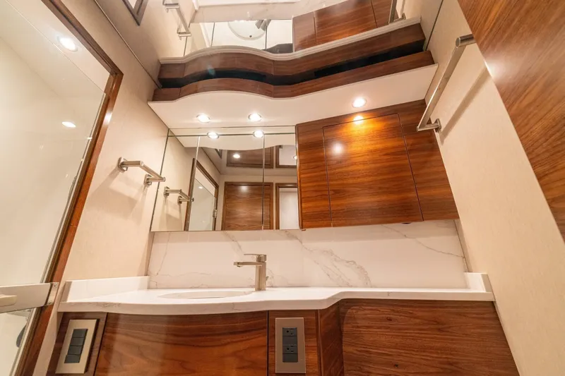 Game On Yacht Photos Pics Luxurious bathroom interior of 2025 Viking 58 Convertible yacht with modern wood finishes.
