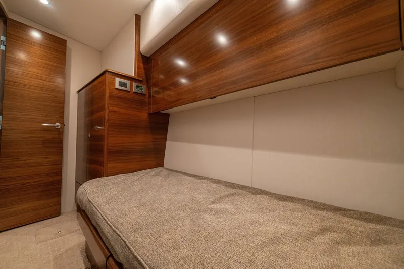 Game On Yacht Photos Pics 2025 Viking 58 Convertible yacht cabin with wooden interior and cozy bed.