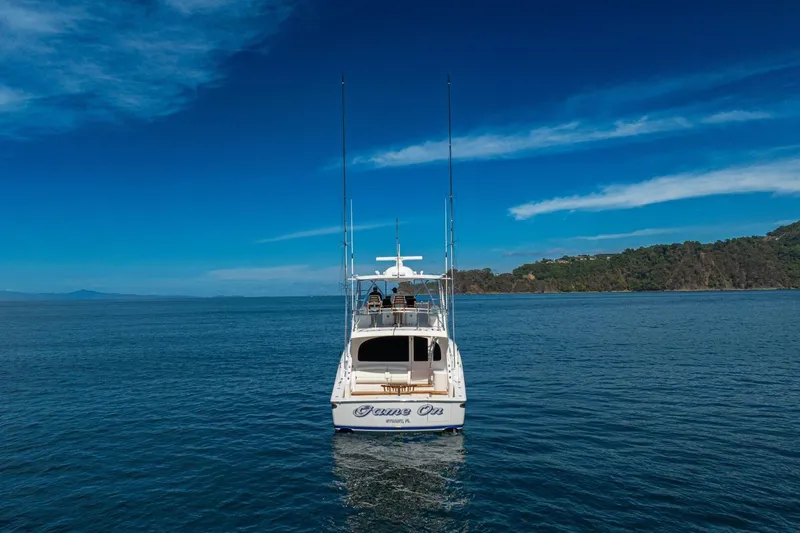 Game On Yacht Photos Pics 2025 Viking 58 Convertible yacht on open sea with clear blue sky.