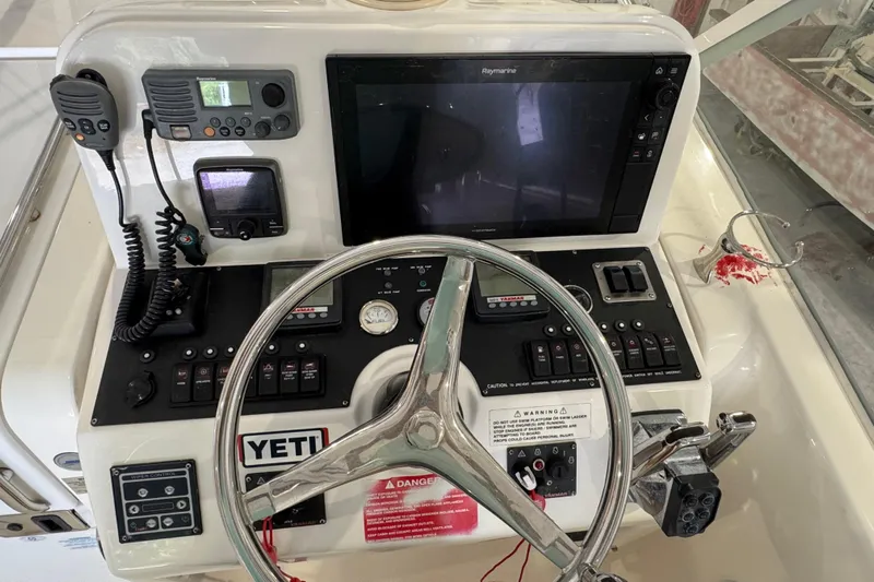 Chasin Tail Yacht Photos Pics Control panel of a 2011 Luhrs 30 Open boat with steering wheel and navigation equipment.