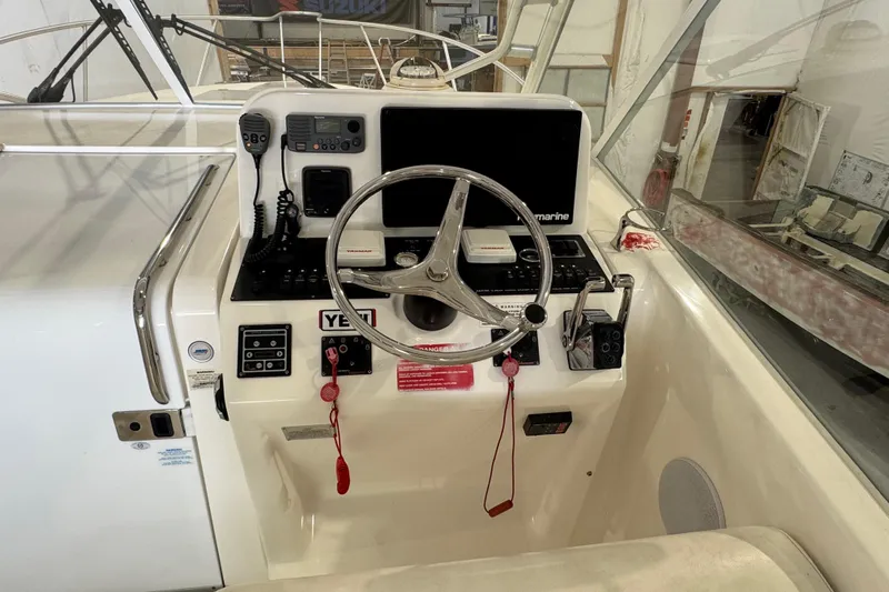 Chasin Tail Yacht Photos Pics Control panel of a 2011 Luhrs 30 Open boat with steering wheel and navigation equipment.