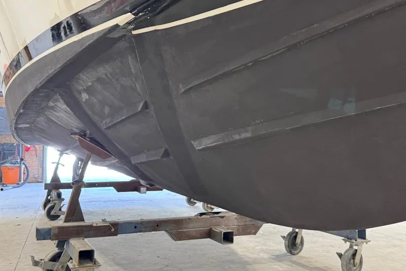 Chasin Tail Yacht Photos Pics 2011 Luhrs 30 Open boat hull on a wheeled stand in a workshop.