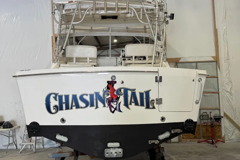 Chasin Tail Yacht Photos Pics 2011 Luhrs 30 Open boat in storage, featuring "Chasin Tail" graphic on the stern.