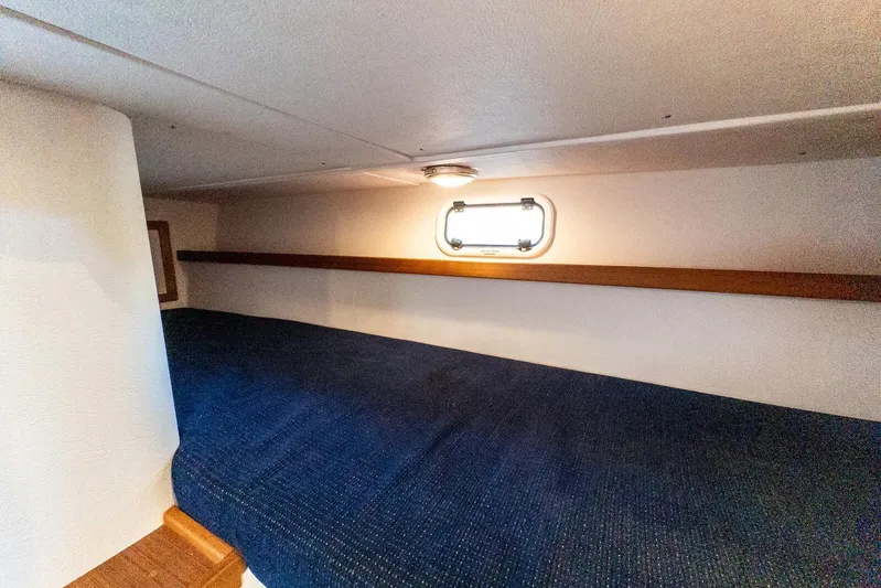  Yacht Photos Pics 2019 Targa 32 boat cabin interior with blue bedding and porthole window.