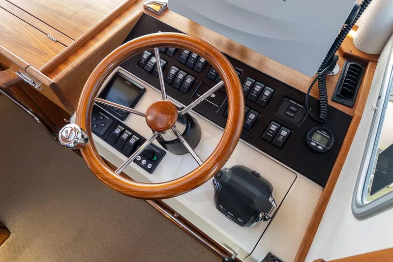  Yacht Photos Pics Steering wheel and control panel of 2019 Targa 32 boat, featuring wood accents and modern instruments.