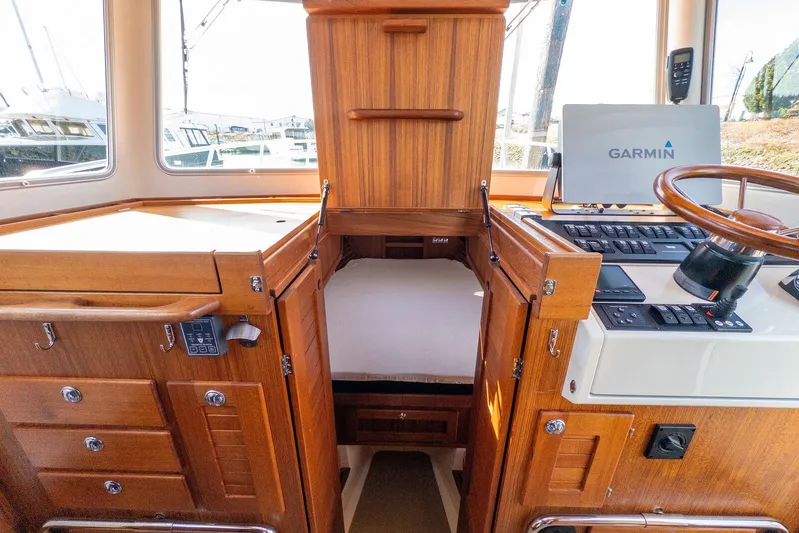  Yacht Photos Pics 2019 Targa 32 boat interior with Garmin navigation, wooden cabinetry, and cozy sleeping area.