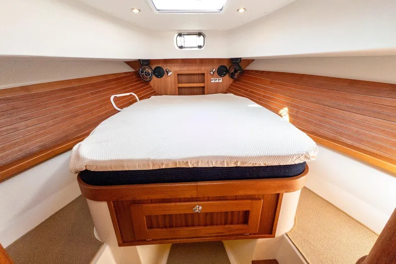  Yacht Photos Pics Cozy cabin interior of 2019 Targa 32 boat with wooden accents and comfortable bedding.
