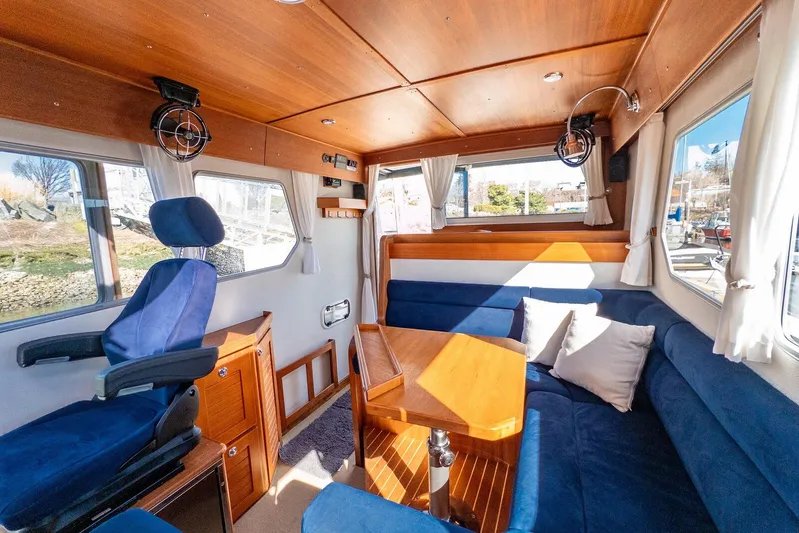  Yacht Photos Pics Interior of a 2019 Targa 32 boat with blue seating and wooden accents.