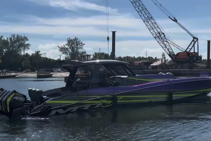 Mr. Bang Yacht Photos Pics 2023 MTI 50v boat with vibrant design docked near construction site.