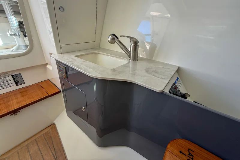  Yacht Photos Pics Interior of 2025 Boston Whaler 330 Vantage with sink and wood accents.