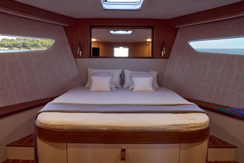  Yacht Photos Pics Luxurious cabin interior of 2024 Patrone 45 OPEN yacht with elegant bedding and scenic windows.