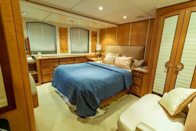  Yacht Photos Pics Luxurious bedroom interior on 2004 Pendennis 155 yacht, featuring elegant wood finishes and cozy bedding.