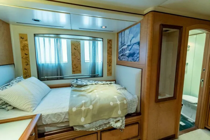  Yacht Photos Pics Luxurious bedroom interior on a 2004 Pendennis 155 yacht, featuring elegant decor and ensuite bathroom.