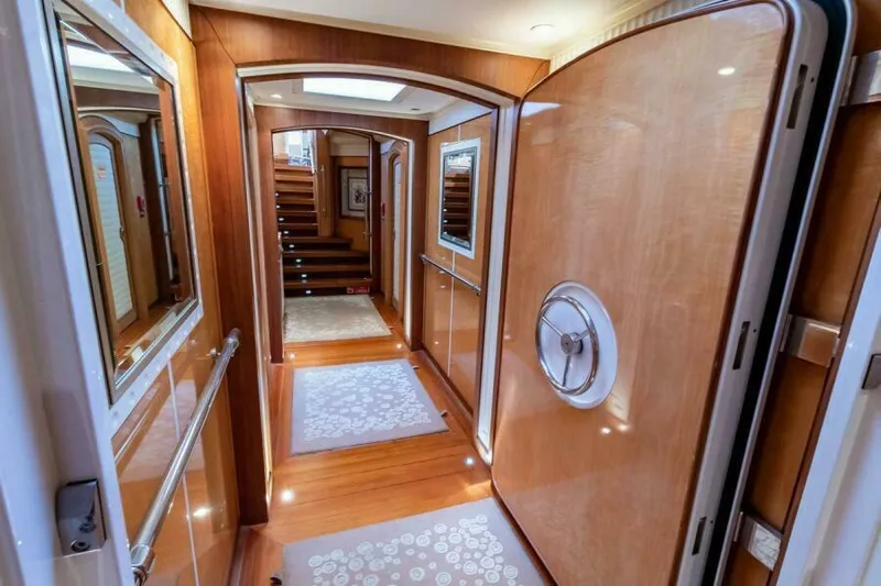  Yacht Photos Pics Luxurious interior hallway of 2004 Pendennis 155 yacht with wooden finishes and elegant decor.