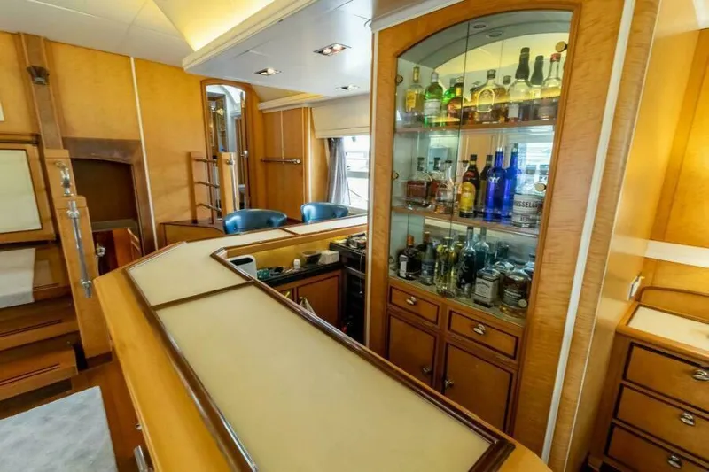  Yacht Photos Pics Luxurious yacht bar interior with wooden cabinetry and stocked liquor display, Pendennis 155, 2004.