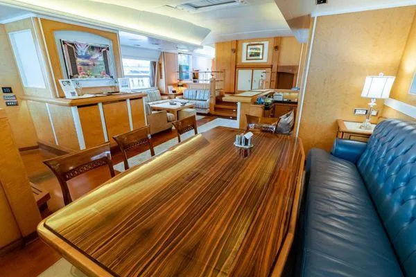  Yacht Photos Pics Luxurious interior of 2004 Pendennis 155 yacht with elegant wood dining table and seating.