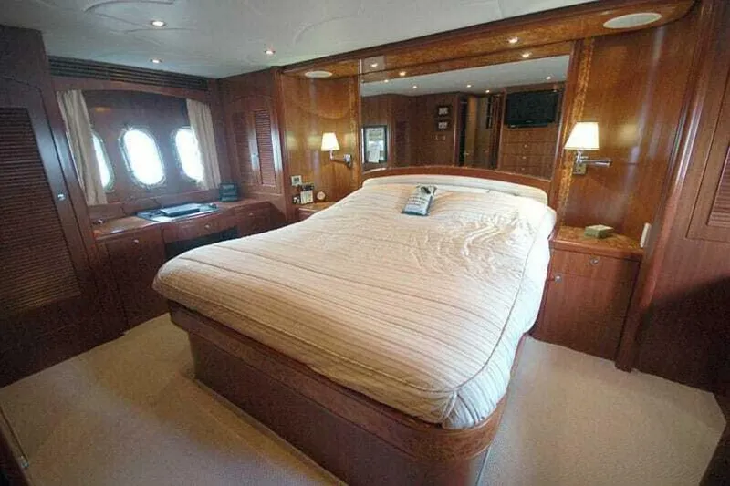 Always Something Yacht Photos Pics Luxurious bedroom interior of 2009 Grand Harbour 66 Motoryacht with wood paneling and large bed.