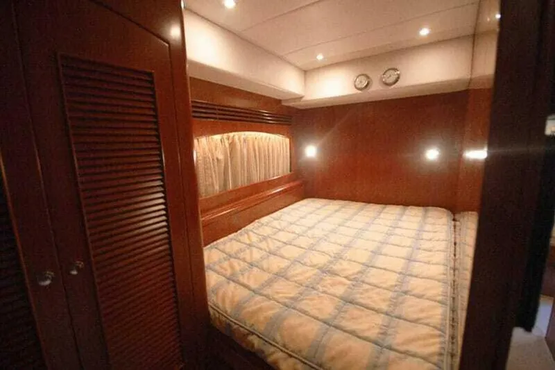 Always Something Yacht Photos Pics Luxurious bedroom in 2009 Grand Harbour 66 Motoryacht with wood paneling and cozy lighting.
