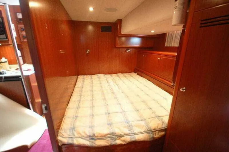 Always Something Yacht Photos Pics Luxurious bedroom interior of 2009 Grand Harbour 66 Motoryacht with wood paneling and cozy bed.