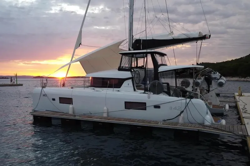 Jack Yacht Photos Pics 2024 Lagoon 42 catamaran docked at sunset, featuring sleek design and modern sails.
