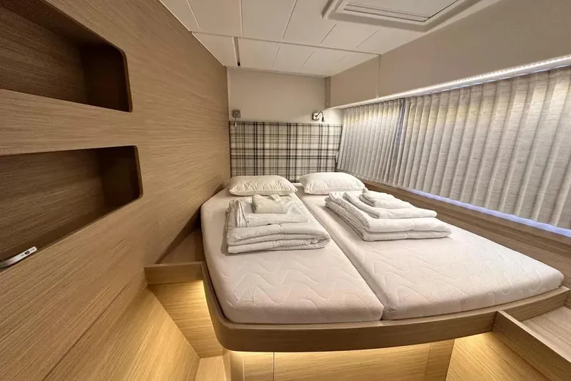 Jack Yacht Photos Pics Luxurious cabin interior of 2024 Lagoon 42 catamaran with neatly arranged bedding.