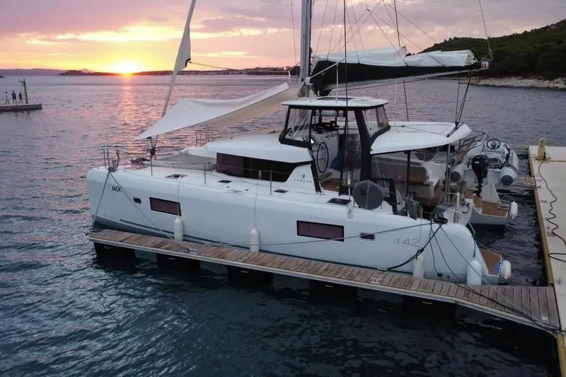 Jack Yacht Photos Pics 2024 Lagoon 42 catamaran docked at sunset, featuring sleek design and modern amenities.