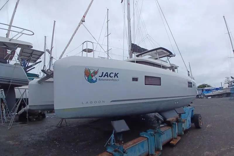 Jack Yacht Photos Pics 2024 Lagoon 42 catamaran on land, featuring "JACK" branding and vibrant logo.