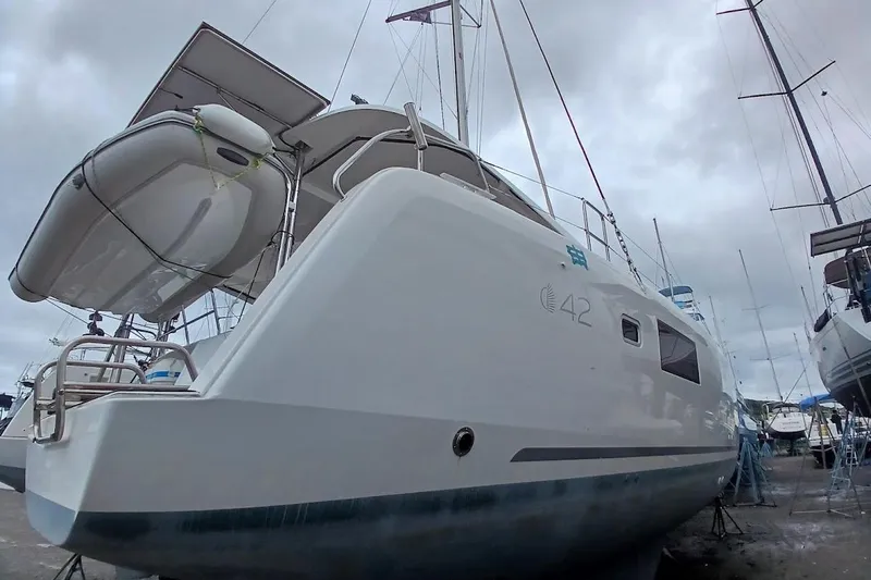 Jack Yacht Photos Pics 2024 Lagoon 42 catamaran on land, showcasing sleek design and modern features.