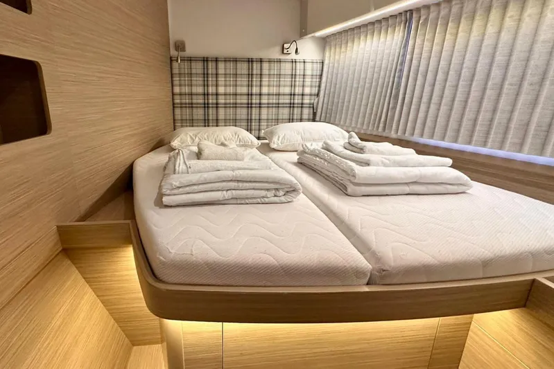 Jack Yacht Photos Pics Luxurious cabin interior of 2024 Lagoon 42 catamaran with cozy bedding and ambient lighting.