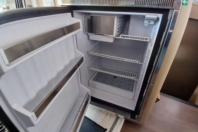 Jack Yacht Photos Pics Open refrigerator inside 2024 Lagoon 42 yacht, showcasing spacious interior and shelving.