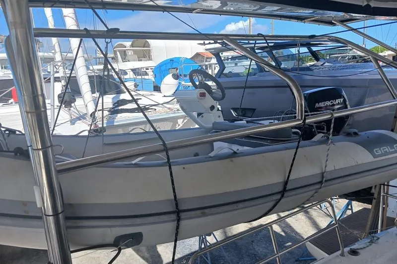 Jack Yacht Photos Pics 2024 Lagoon 42 catamaran with dinghy and Mercury outboard motor in marina.