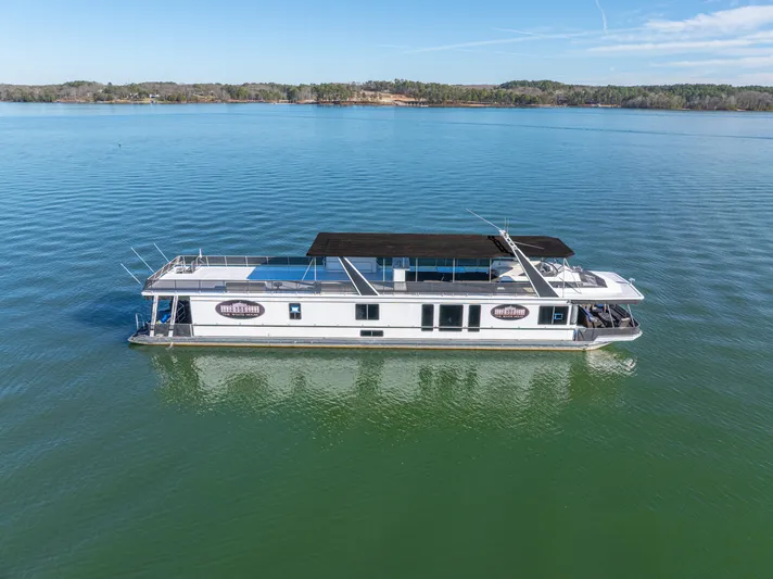  Yacht Photos Pics 1998 Stardust Cruisers Custom Luxury Houseboat on serene lake under clear blue sky.