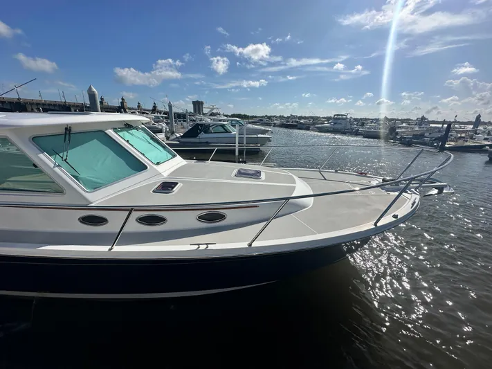 Tlc Yacht Photos Pics 2014 Back Cove 37 boat docked in a sunny marina, surrounded by other vessels.