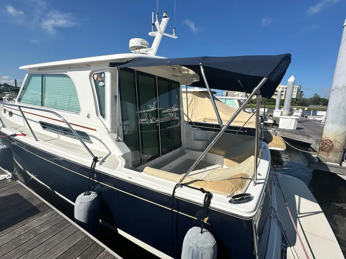 Tlc Yacht Photos Pics 2014 Back Cove 37 yacht docked, featuring a blue canopy and sleek design.