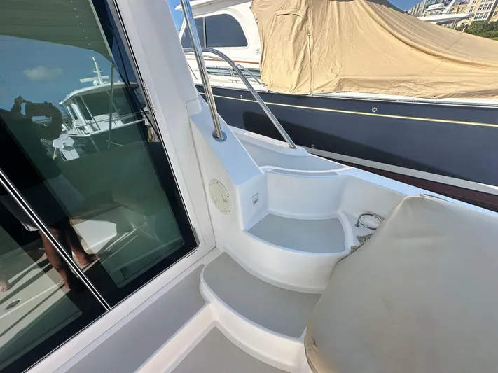 Tlc Yacht Photos Pics 2014 Back Cove 37 yacht deck with seating and railing, docked beside another boat.