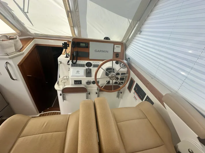 Tlc Yacht Photos Pics 2014 Back Cove 37 helm with Garmin navigation, beige seating, and wooden accents.