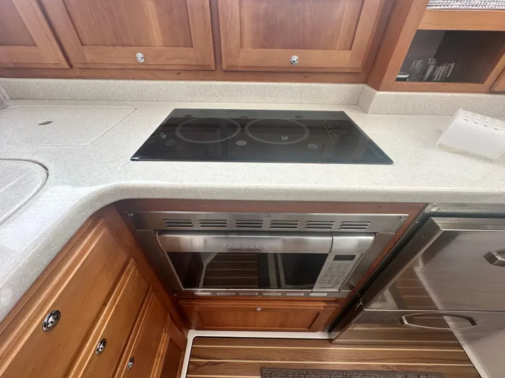 Tlc Yacht Photos Pics 2014 Back Cove 37 yacht kitchen with stove, microwave, and wooden cabinetry.