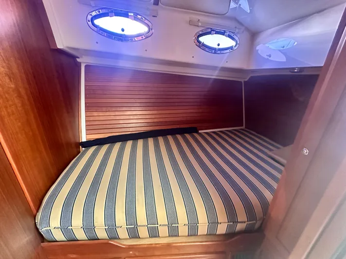 Tlc Yacht Photos Pics Cozy cabin interior of 2014 Back Cove 37 with striped bedding and portholes.