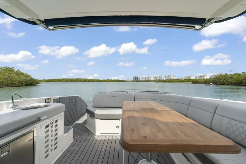  Yacht Photos Pics 2022 Sea Ray SLX 400 Outboard boat interior with seating and table, scenic water view.