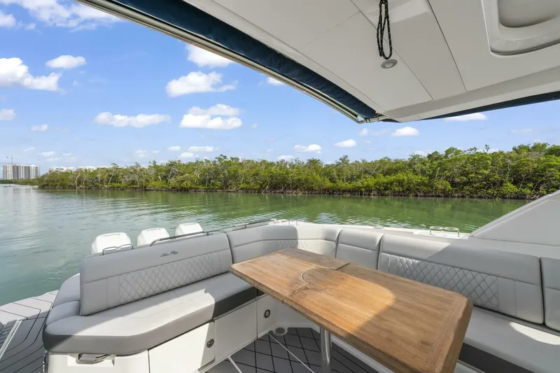  Yacht Photos Pics Luxury seating area on 2022 Sea Ray SLX 400 Outboard, overlooking serene water and lush greenery.