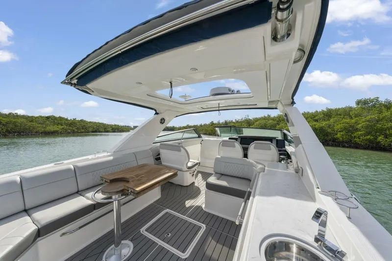  Yacht Photos Pics 2022 Sea Ray SLX 400 Outboard luxury boat interior with seating and table, on calm water.