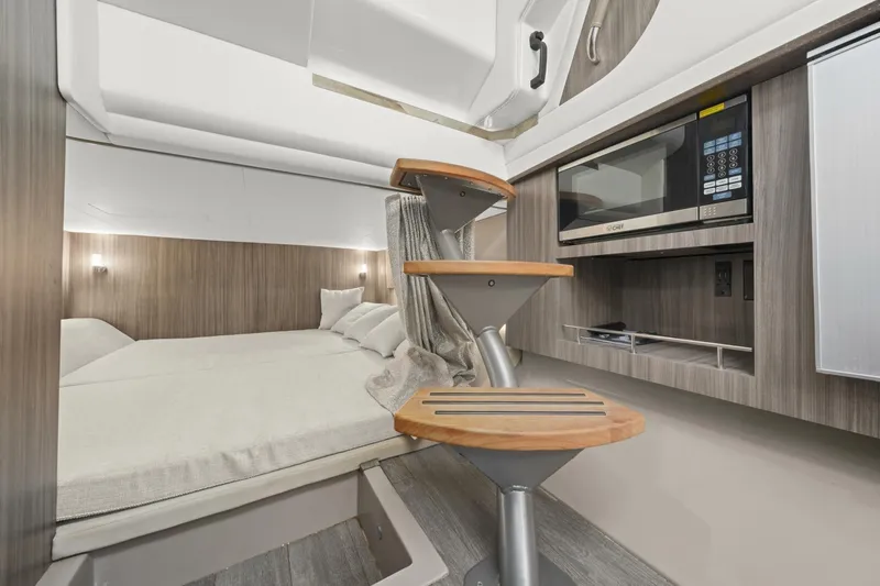  Yacht Photos Pics 2022 Sea Ray SLX 400 Outboard cabin interior with bed, stairs, and microwave.